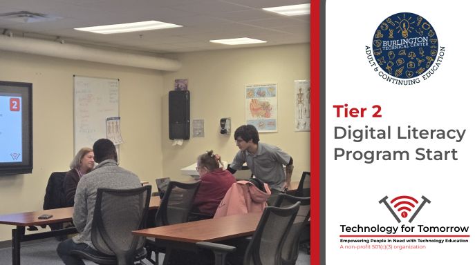 Damien helps students with a nondescript lesson plan in the background hosted at Burlington's Technical Center